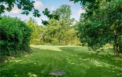 a lush green field with trees in the background at Cozy Home In Asperup With Sauna in Asperup
