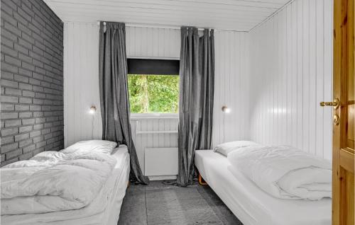 two beds in a room with a window at Cozy Home In Asperup With Sauna in Asperup