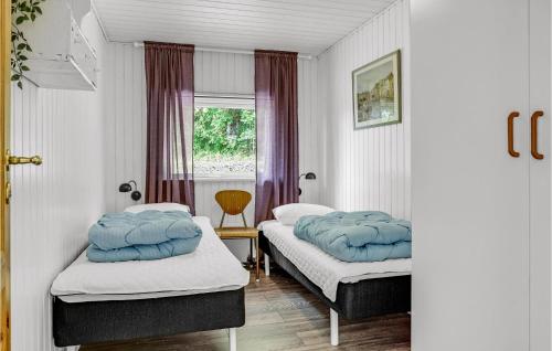 two beds in a room with a window at Cozy Home In Asperup With Sauna in Asperup