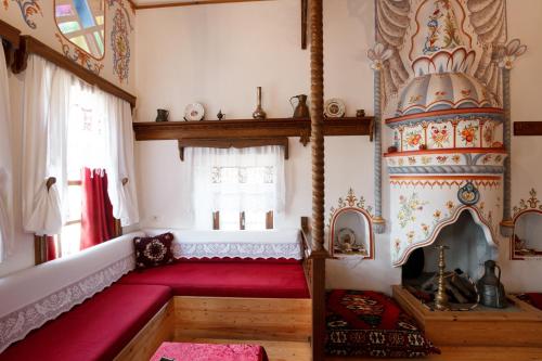 a living room with a red couch in a room with aburning at Boutique Hotel Musée in Gjirokastër