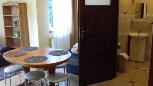 a small kitchen with a table and stools in a room at Pokoje u Ani in Zastań