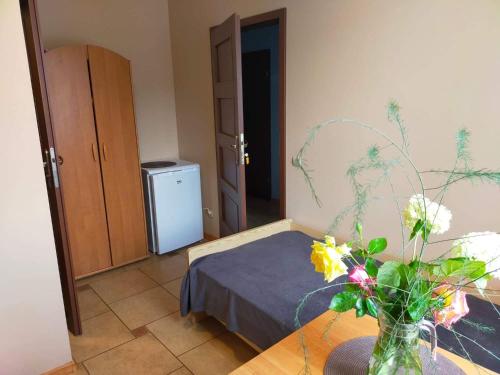 a room with a bed and a vase of flowers on a table at Pokoje u Ani in Zastań