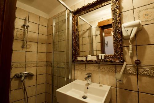a bathroom with a sink and a mirror at Boutique Hotel Musée in Gjirokastër