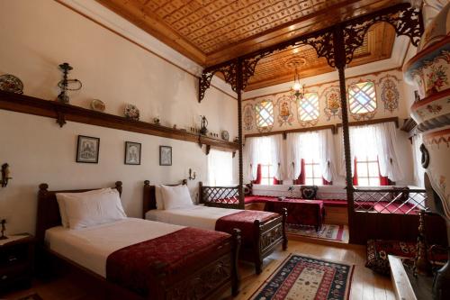 a bedroom with two beds in a room with windows at Boutique Hotel Musée in Gjirokastër