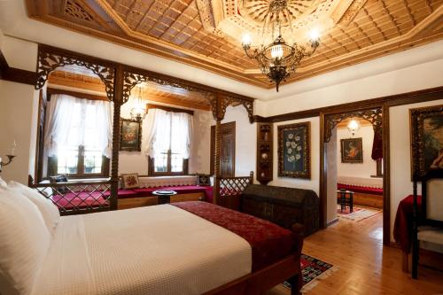 a bedroom with a bed and a chandelier at Boutique Hotel Musée in Gjirokastër