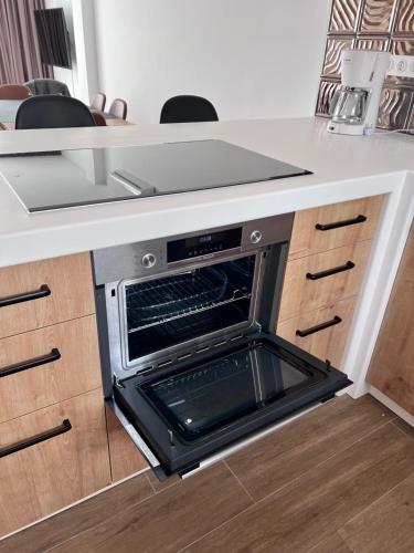 a kitchen with an open oven under a counter at Casa LARA in Empuriabrava