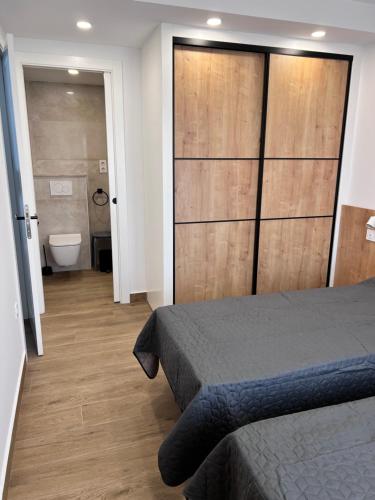 a bedroom with a bed and a bathroom with a toilet at Casa LARA in Empuriabrava