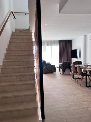 a staircase in a living room with a table at Casa LARA in Empuriabrava