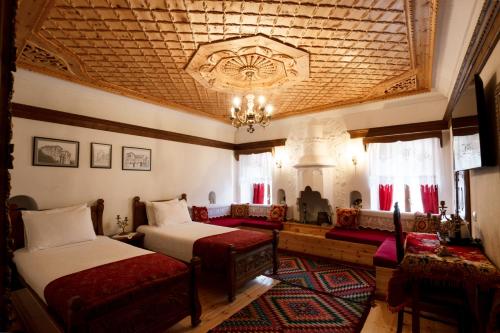 a bedroom with two beds and a chandelier at Boutique Hotel Musée in Gjirokastër