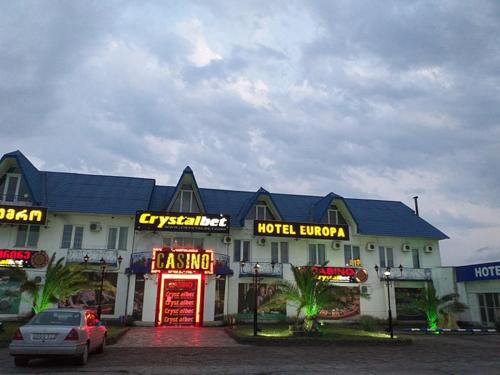 a large building with neon signs in a parking lot at Europa Hotel-Kutaisi in Kutaisi