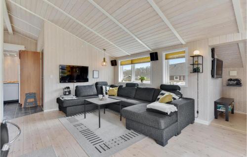 a living room with a couch and a table at Holiday Home Pøt Strandby Ii Juelsminde I in Sønderby