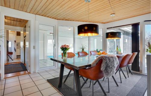 a dining room with a glass table and chairs at Pet Friendly Home In Knebel With Sauna in Skødshoved Strand