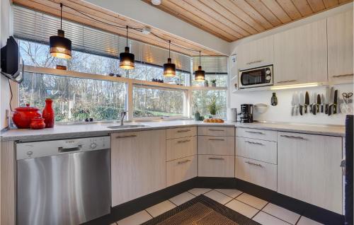 a kitchen with white cabinets and a window at Pet Friendly Home In Knebel With Sauna in Skødshoved Strand
