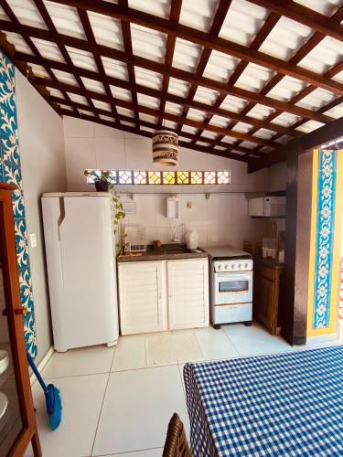 a kitchen with a refrigerator and a stove at Pontal dos Sonhos- Chalés Praia do Farol in Coruripe