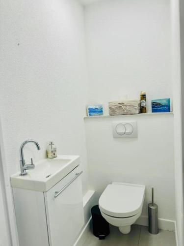 une salle de bain blanche avec des toilettes et un lavabo dans l'établissement Modern Bright Cannes Apt 2 min walk to the Beach, à Cannes