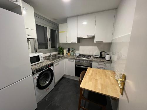 a kitchen with a washing machine and a table at Rooms in Apartment Rambla Catalunya in Barcelona