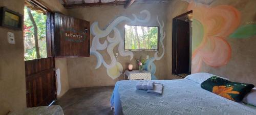 a bedroom with a bed and a painting on the wall at Pousada com chalés na serra da Meruoca in Meruoca