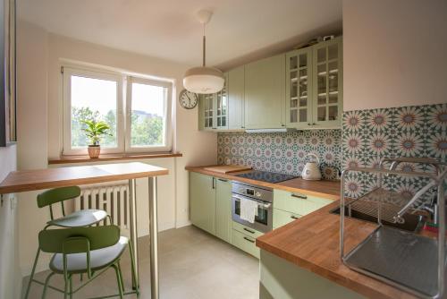 a kitchen with green cabinets and a table and chairs at ODPOCZINK 2-pokojowe mieszkanie w centrum in Gdynia