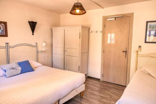 a bedroom with two beds and a closet and a door at Hôtel Boquier, Avignon Centre in Avignon