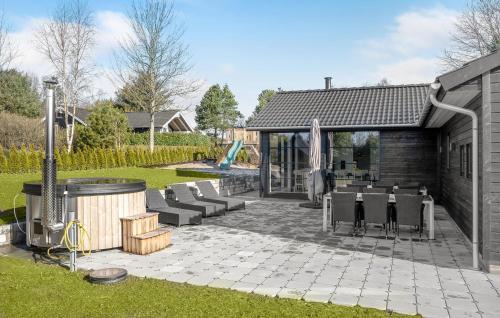 a patio with a table and chairs in a yard at Cozy Home In Ebeltoft With Sauna in Ebeltoft