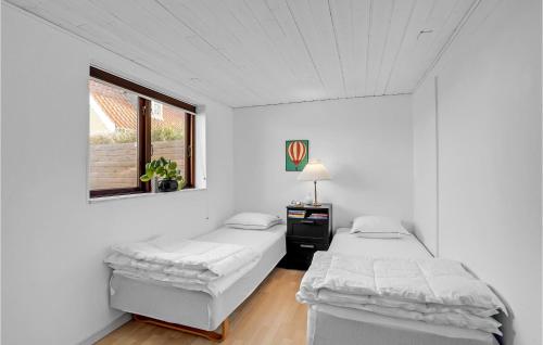 two beds in a white room with a window at 4 Bedroom Lovely Home In Væggerløse in Væggerløse