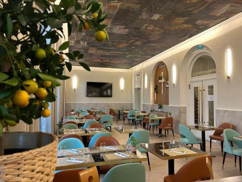 a restaurant with tables and chairs and a ceiling with fruit at Brit Hotel Privilège Le Royal - Centre Gare in Troyes