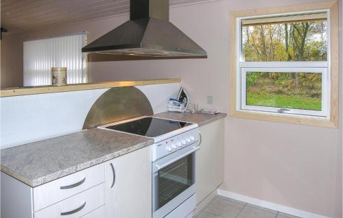 a kitchen with a stove top oven next to a window at Holiday Home Ternevej Iii in Kare