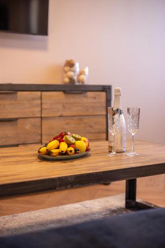 a table with a plate of fruit and a bottle of wine at Penzion MartInn in Martin