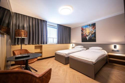 a hotel room with two beds and a table at Penzion MartInn in Martin