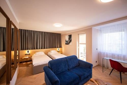 a bedroom with a bed and a blue couch at Penzion MartInn in Martin