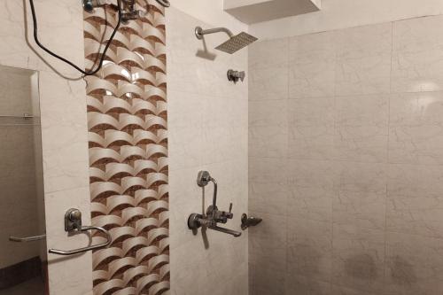 a shower with two shower heads in a bathroom at Hotel Rang Mahal Near Jaipur International Airport in Jaipur
