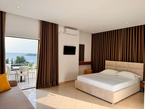 a bedroom with a bed and a view of the ocean at Dine Hotel in Ksamil