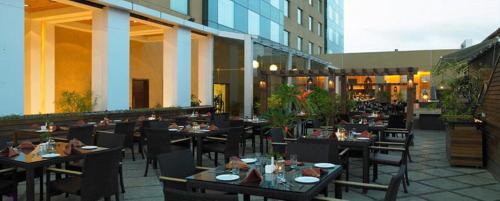 a restaurant with tables and chairs in front of a building at Royal Orchid Central, Pune in Pune