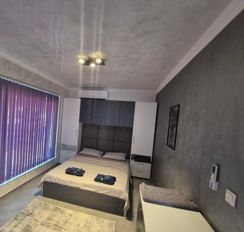 a bedroom with two beds and a large window at Ivon Apartments in Sozopol
