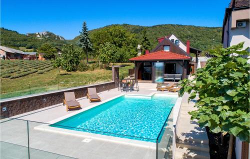 a swimming pool with two chairs and a house at Cozy Home In Kalnik With Sauna in Kalnik