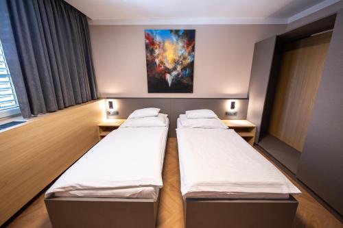 a hospital room with two beds and a painting on the wall at Penzion MartInn in Martin