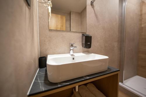 a bathroom with a white sink and a shower at Penzion MartInn in Martin