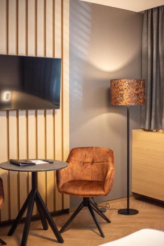 a room with a table and a chair and a lamp at Penzion MartInn in Martin