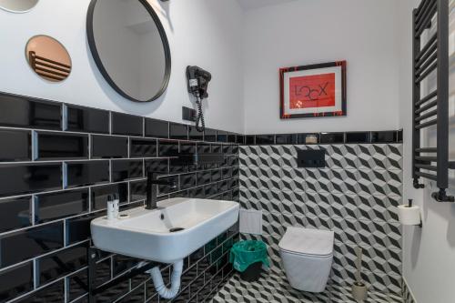 a bathroom with black and white tiled walls and a sink at Loox Ostrovo- Boutique House-noclegi nad morzem in Ostrowo