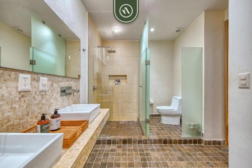 Un baño con dos lavabos y una ducha y un inodoro. en Haixa A107, en Higuera Blanca