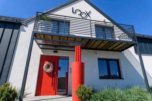 a house with a red door and a red pole at Loox Ostrovo- Boutique House-noclegi nad morzem in Ostrowo
