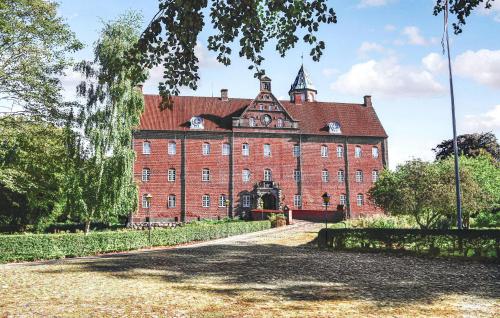 an old red brick building with a tower at Awesome Home In Grenaa With Sauna in Brøndstrup