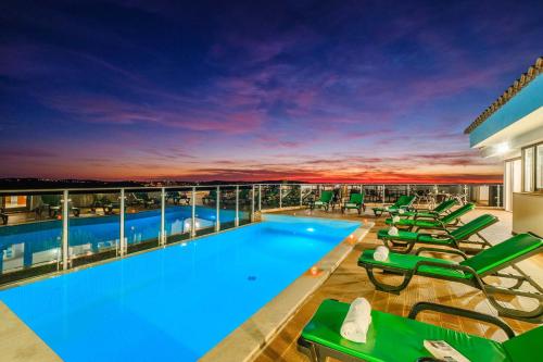 a pool on the roof of a building with lounge chairs at Villa Alte Springs by Algarve Vacation in Alte