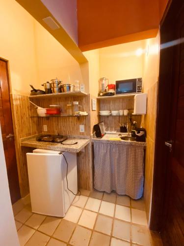 a small kitchen with a counter and a sink at Pontal dos Sonhos- Chalés Praia do Farol in Coruripe