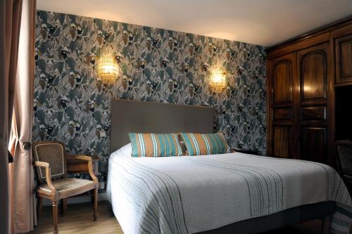 a bedroom with a bed and a chair at Maison CHILO in Barcus