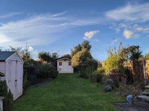une cour avec une maison blanche et une clôture dans l'établissement Lobster Pot Cottage, à Fulmodeston