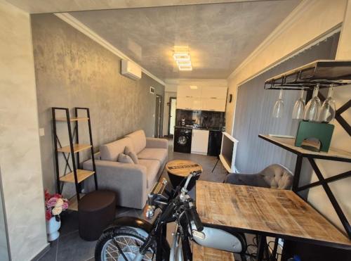 a living room with a couch and a bike in a room at Ivon Apartments in Sozopol