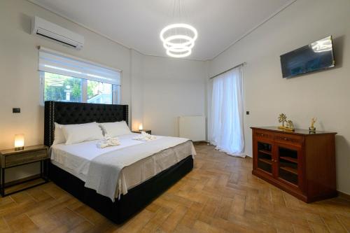 a bedroom with a bed and a dresser and a window at Villa Aegea in Kalamata
