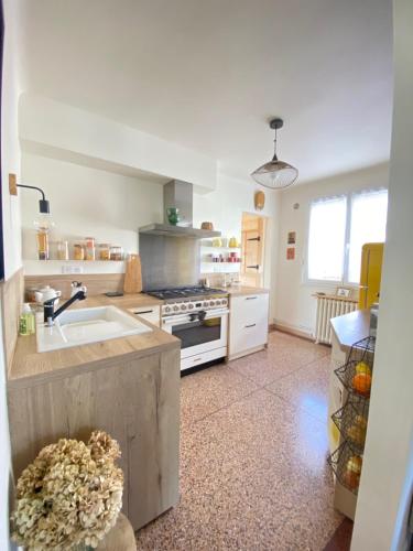 une cuisine avec un évier et une cuisinière dans l'établissement Petite maison de vacances, à Oloron-Sainte-Marie