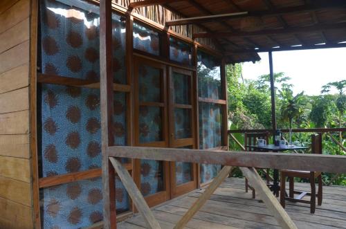 a porch of a house with a bench on it at Roça Maria Helena-Príncipe in Santo António